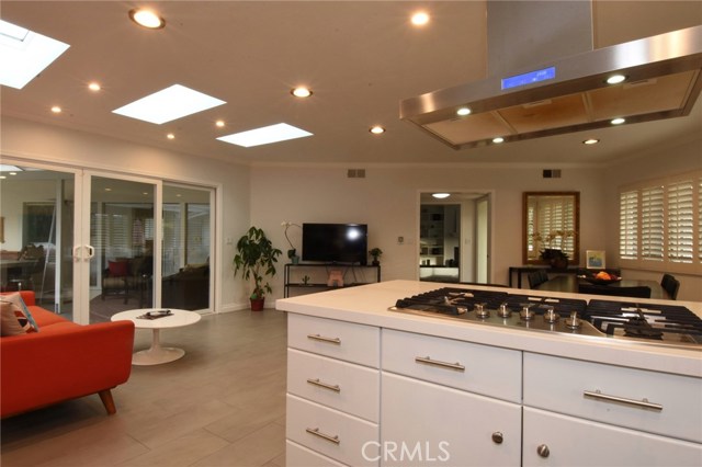 Terrific view of the kitchen, looking toward the dining room/family room.  Wall of windows/slider opens to the patio and pool area beyond.