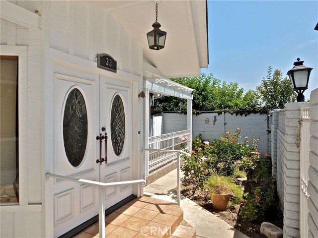 Double doors at the formal entry, rose garden in the front courtyard, and sun porch from one of the 4 bedrooms.