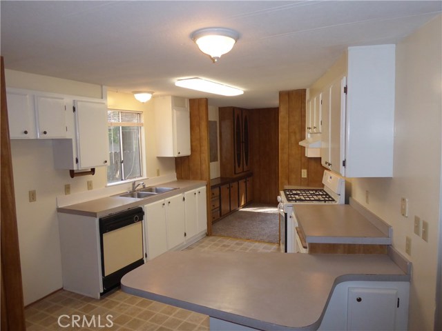 Kitchen with a new Whirlpool gas stove and new flooring.