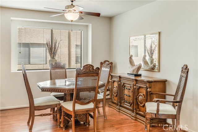 Dining area with ceiling fan and wood floors.