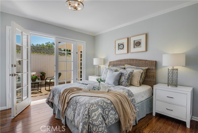 Master bedroom has hardwood floors and attached bath and opens to charming brick patio