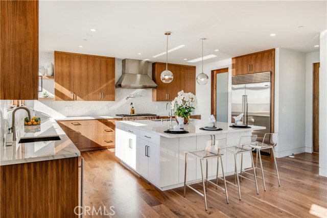 Kitchen facing north east with center island and sub zero, pantry to the left