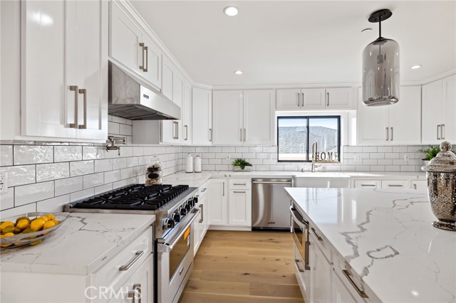 Bright, expansive and inviting kitchen with abundant custom cabinetry, quartz counters and deluxe appliances