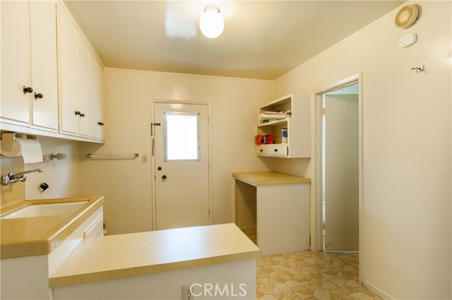 Laundry area with tub, lots of counter space and room for a small freezer.