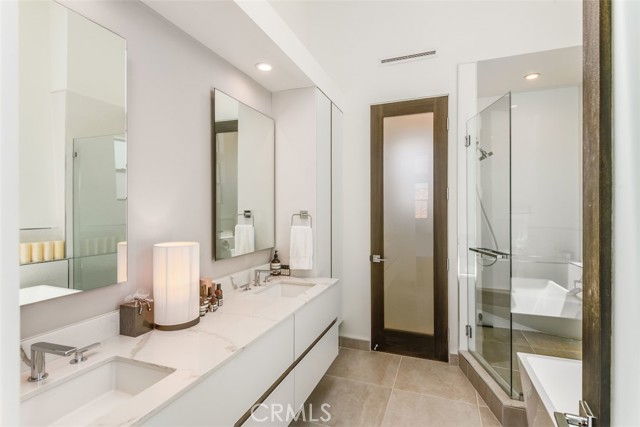 Beautiful primary bath with quartz dual vanitiy, frameless walk-in shower, soaking tub and more