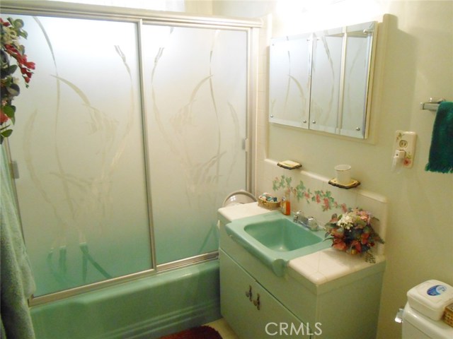 Hallway Main Bathroom; Shower/Tub Combo. Vanity Cabinet with Tiled Counter Tops and Double Mirrors.