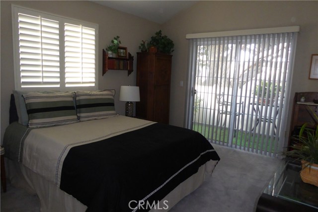Guest Bedroom #1 with plantation shutters + balcony.