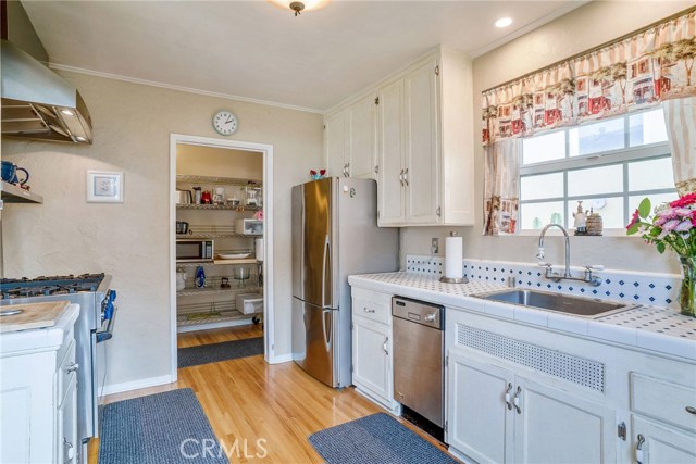 FRONT HOUSE KITCHEN WITH A GORGEOUS THERMADOR GAS STOVE AND WALK IN PANTRY/ LAUNDRY ROOM.