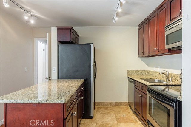 Granite counters, travertine floors, stainless steel appliances, and new cabinets are all featured in the remodeled kitchen