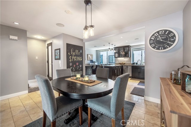 Beautiful dining room with custom lights, travertine tiles and an open and bright layout