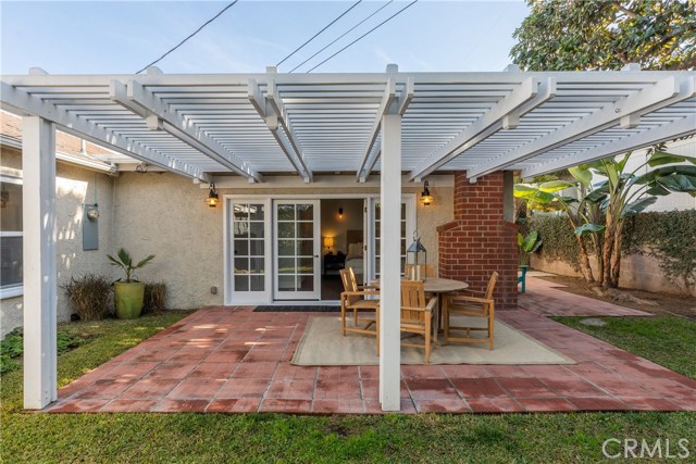 The primary bedroom's French doors open to a relaxing patio and lush backyard.
