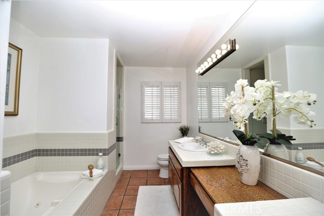 Master bathroom with double vanities, jacuzzi tub, and stall shower.