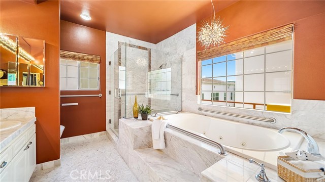 Master bath from entry with dual sinks, automatic Toto toilet, a spa bathtub, large shower and beautiful, specialized tile.