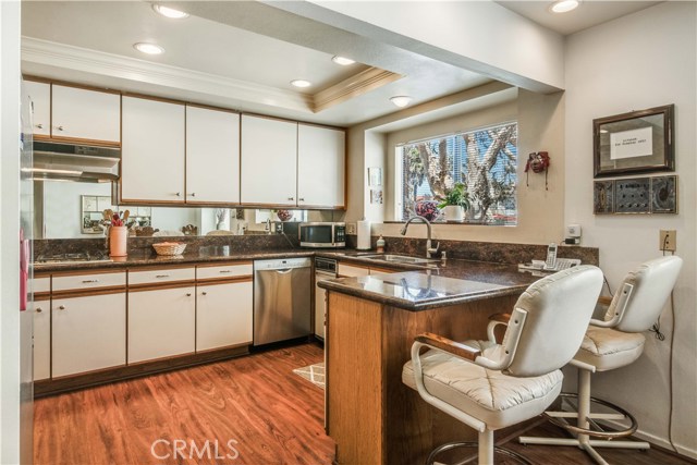 Kitchen has beautiful granite countertops, all the way around through the breakfast bar. Includes trash compactor, refrigerator, dishwasher, cooktop with vented hood. Laundry room is conveniently located through the kitchen behind pocket door.