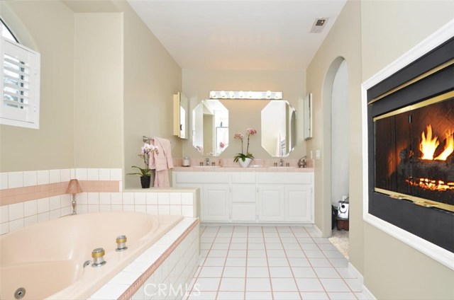 Master bathroom with spa tub, fireplace and double sinks