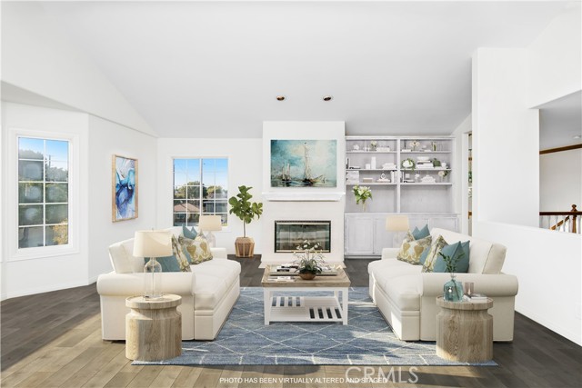 Photos have been altered to show the living room wood painted white with wood floors and virtually staged.