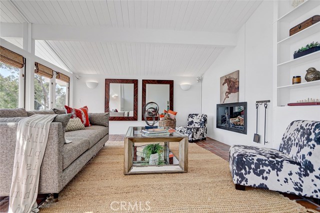 Living room features wall of windows and vaulted ceilings.