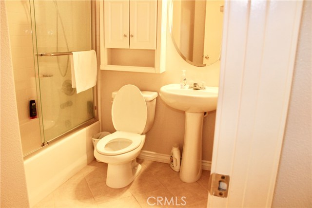 First floor bathroom with bathtub and tile flooring.