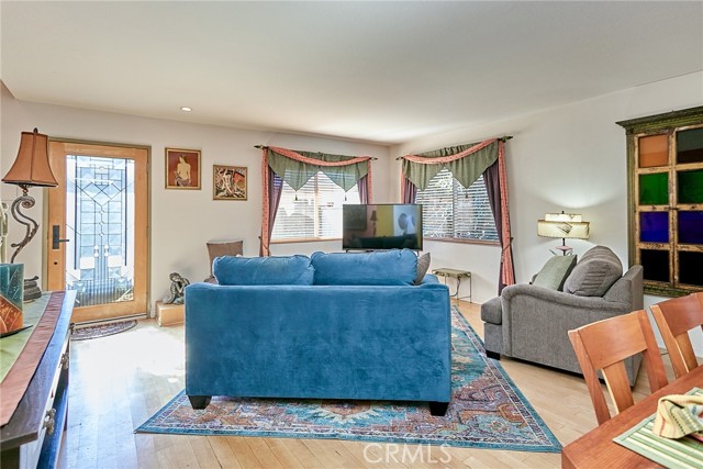 An exquisite art deco decorative glass and maple wood front door lead you into the main floor living/dining room with maple hardwood floors and wooden blinds.