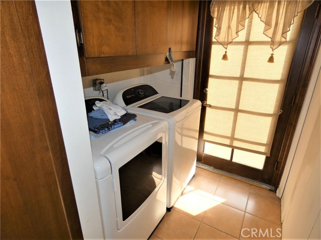 Laundry room in home fits full-size washer and dryer with tiled floor & French door access to rear deck.