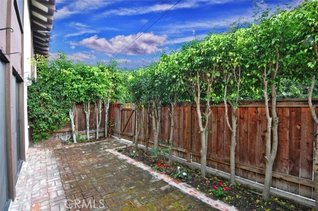 View of the large brick patio area and garden located off the two bedrooms in Unit 107.