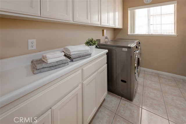 Large laundry room w/ cabinetry and counter for easy folding