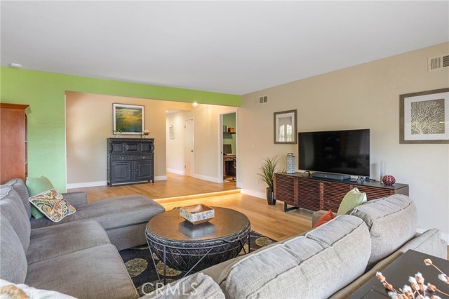 From front corner of living room looking back towards entry (on left behind green wall) and into main bedroom (on right).