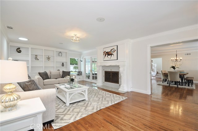 Living room opening into dining room with french doors to pool