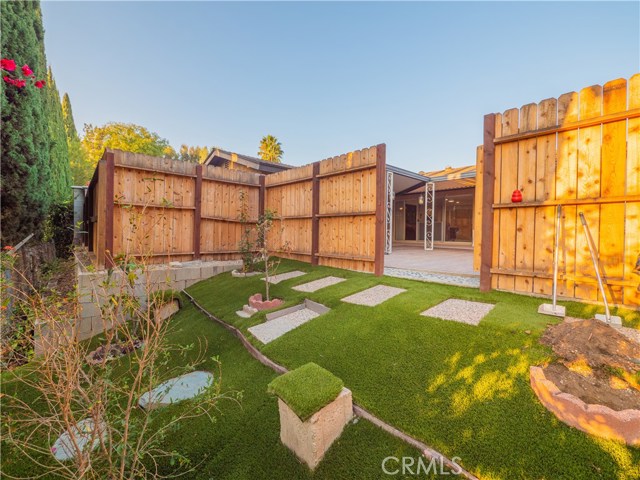 Small orchid and gardening area behind cedar fence