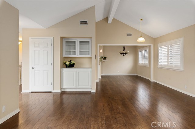 View from the Living room facing the formal dining area and kitchen nook.  Built-in cabinetry and hall closet, plantation shutters and High vaulted Ceilings.