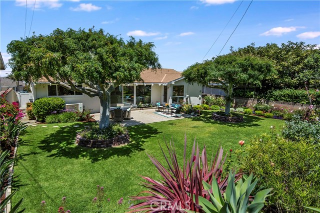 This yard is incredible with mature Chinese Elm trees and flower filled borders.