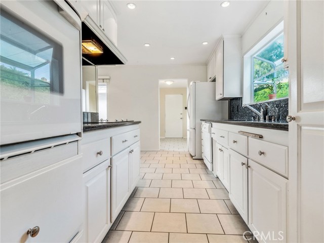 The kitchen offers clean and stylish white cabinetry, granite counter tops, with an ample sized breakfast nook.