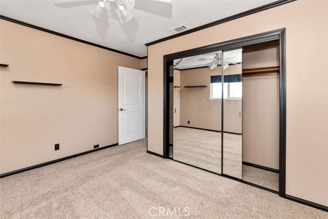 Upstairs bedroom with large mirror sliding closet door and plush carpeting