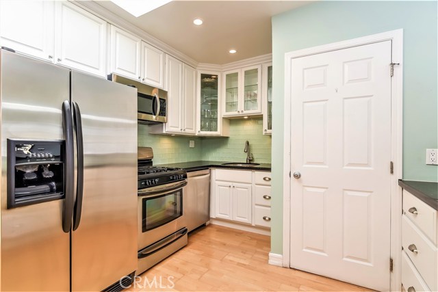 The kitchen has clean white finished wood cabinets with lots of storage drawers.