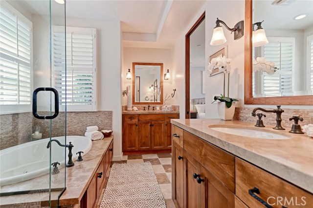 Enjoy separate dual sinks in master bathroom with custom light fixtures.