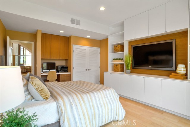 Downstairs bedroom overlooks the back yard and doubles as a perfect guest suite, family room or home office.  Note the built-in wall unit and desk.  Laundry area is behind the white doors.  Additional laundry hook-ups in the garage.