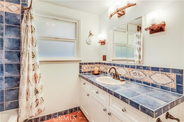 Bathroom #1 with terracotta floor tiles and mosaic backsplash with plenty of countertop space