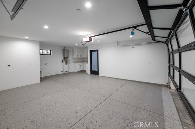 Generously sized garage with epoxy floors and full scale laundry room.  Outside the garage, you will  find additional carport spaces granting even more of the highly desired beach city parking