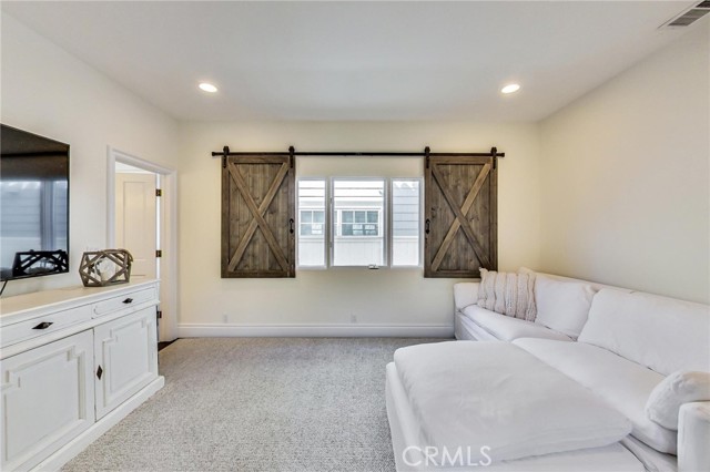 Entry level bedroom used as den. Large closet on right. French doors could be switched out for privacy doors if this is used as a bedroom. Jack n Jill bathroom door visible at left. Love the barn door shutters!
