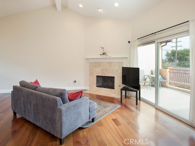 Living room welcomes a stylish fireplace with vaulted ceilings and recessed lighting.