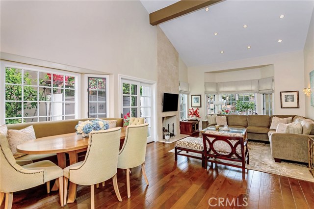 An abundance of natural lighting brightening the corner banquette area, family room w/vaulted ceiling and fireplace.