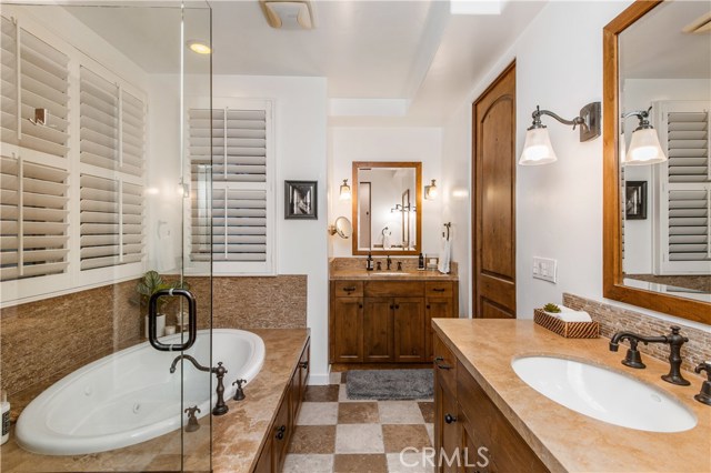 Master bathroom features a spa-like tub, dual vanities, private water closet and a walk-in shower.