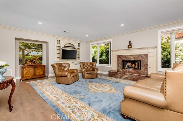 Family room with built in bookshelves and media center and marble fireplace