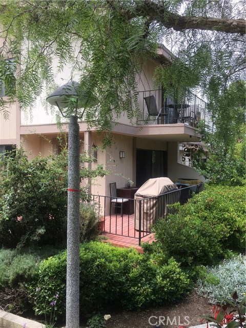 View from the garden walkway to the front patio(front door is to the left)and upper balcony from the master bedroom.