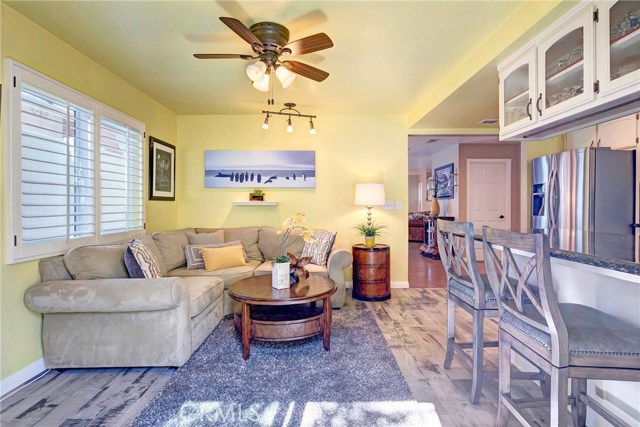 Sunny, light-filled kitchen with breakfast bar, beautiful tile backsplash, tons of cabinet storage, stainless appliances, granite counters, recessed lighting, adjacent family room, and backyard access.