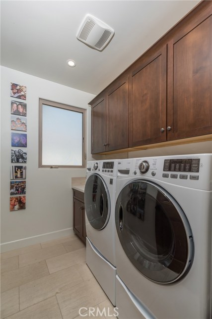 Large dedicated laundry room upstairs with tons of cabinetry and utility sink too!