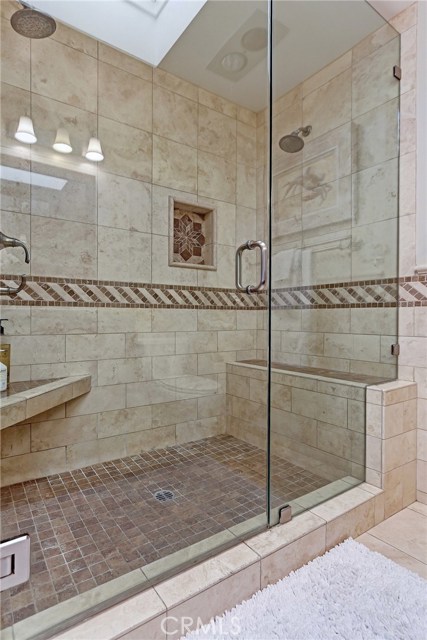 Master Bathroom shower with dual shower heads and built-in bench.