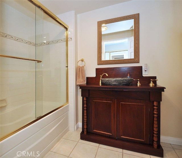 Master FULL bath with stone vessel sink and tiled shower/bath and floor.