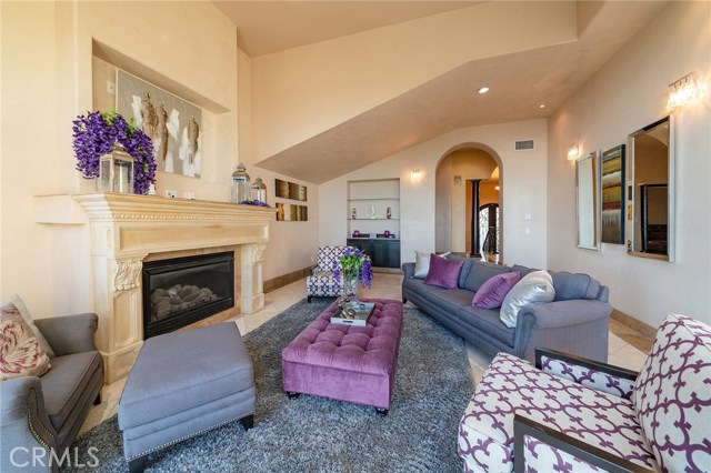 Formal living room with exquisite fireplace and architectural detail. Ocean views and access to the viewing patio from this room too!