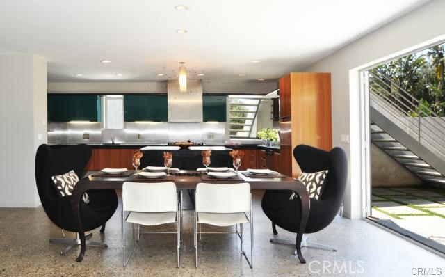 A perfectly symmetrical shot of the dining room into the kitchen. Note the stair cases going up to the party deck above the kitchen..